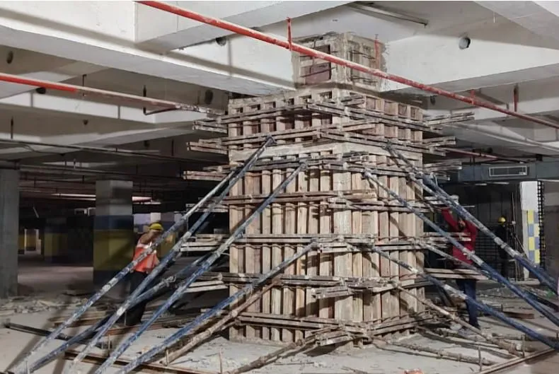 Column formwork braced with steel props inside an occupied building floor